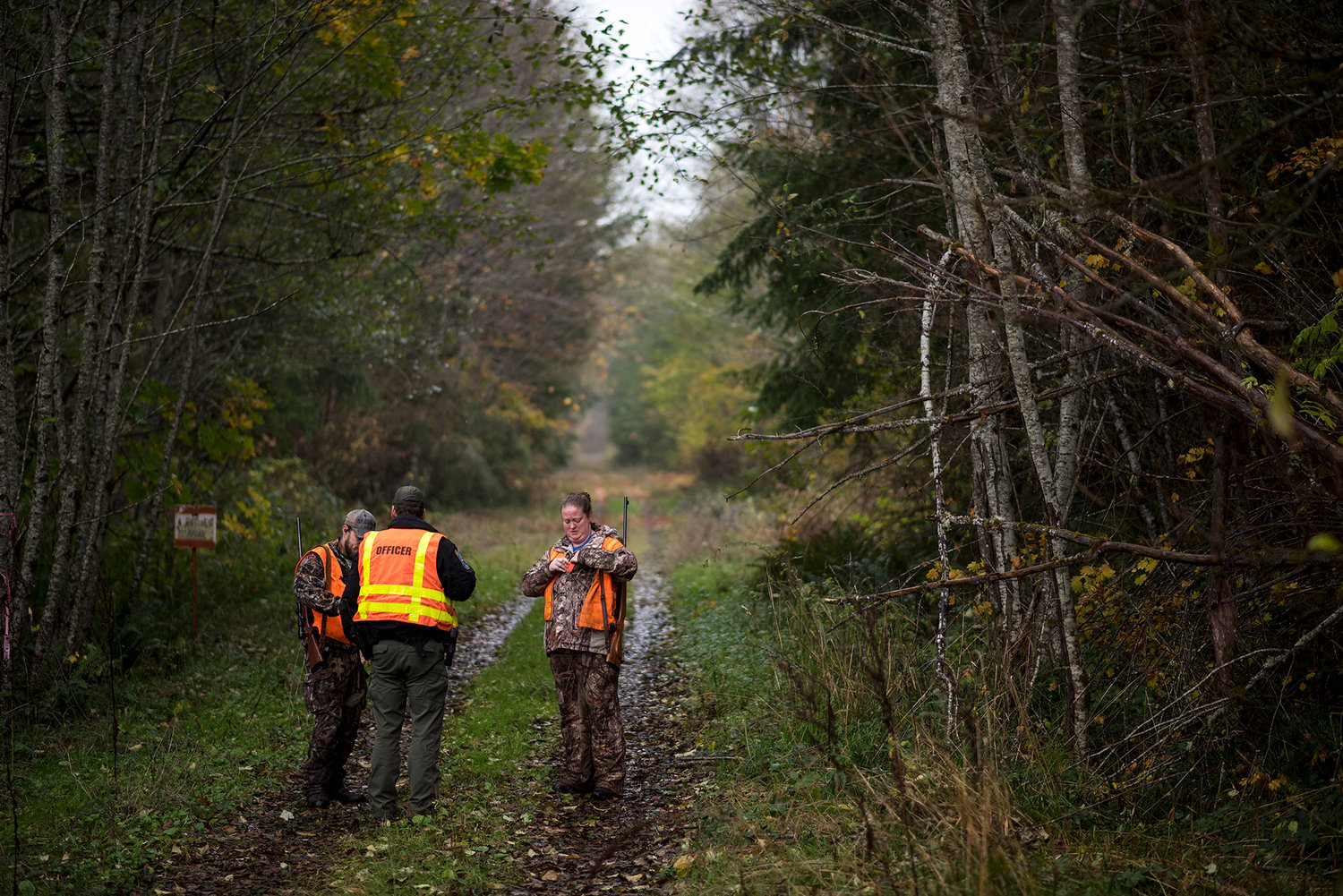 FILE PHOTO — A WDFW Officer checks to see if a pair of hunters have their elk-hunting tags west of Ryderwood in this Chronicle file photo.