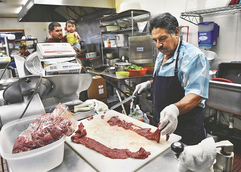 Taco Gabys co-owner Narciso Mendez prepares meat on Tuesday, July 29, for carne asada.