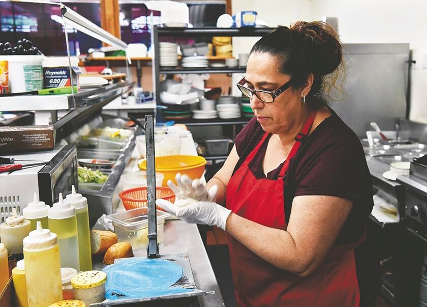 Taco Gabys co-owner Martha Mendez prepares ingredients on Tuesday, July 29, that she will press into a machine to make tortillas.