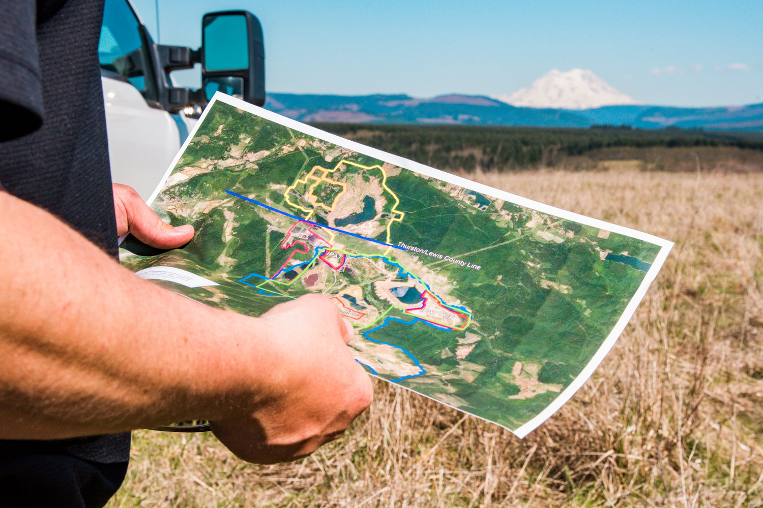 Cody Duncan holds up a map while overlooking TransAlta property near Centralia in April.
