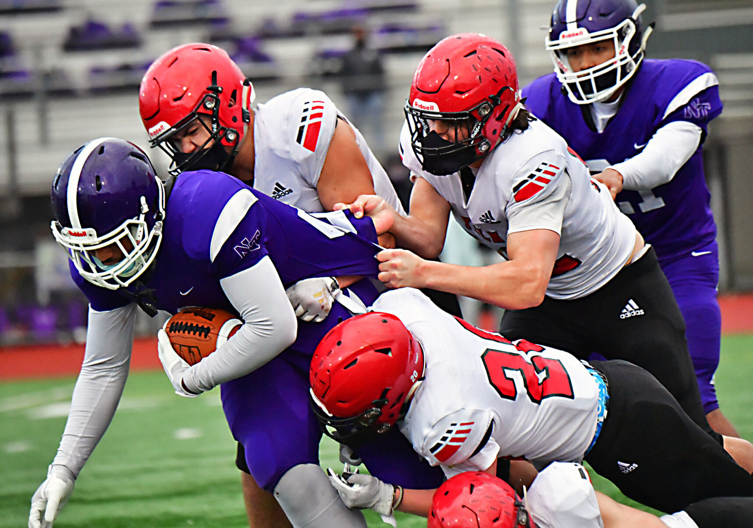 A trio of Yelm High School defenders keep North Thurston High School running back Armani Tonual out of the end zone in the fourth quarter on Friday, March 19, at South Sound Stadium.