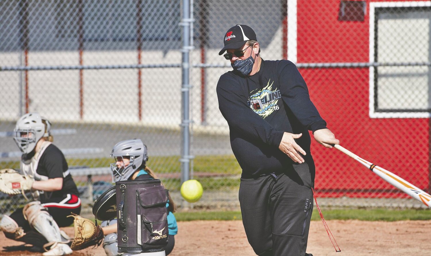 Russ Riches, Yelm High School softball junior varsity coach, hits ground balls to players during practice on Wednesday, March 17.