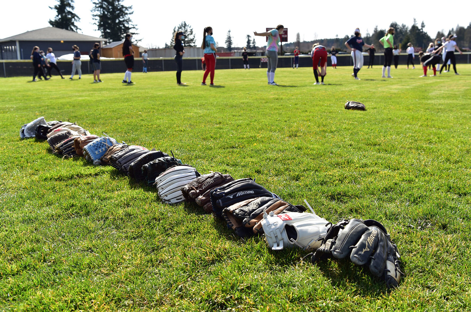 Yelm High School softball players stretch in the outfield during practice on Wednesday, March 17.