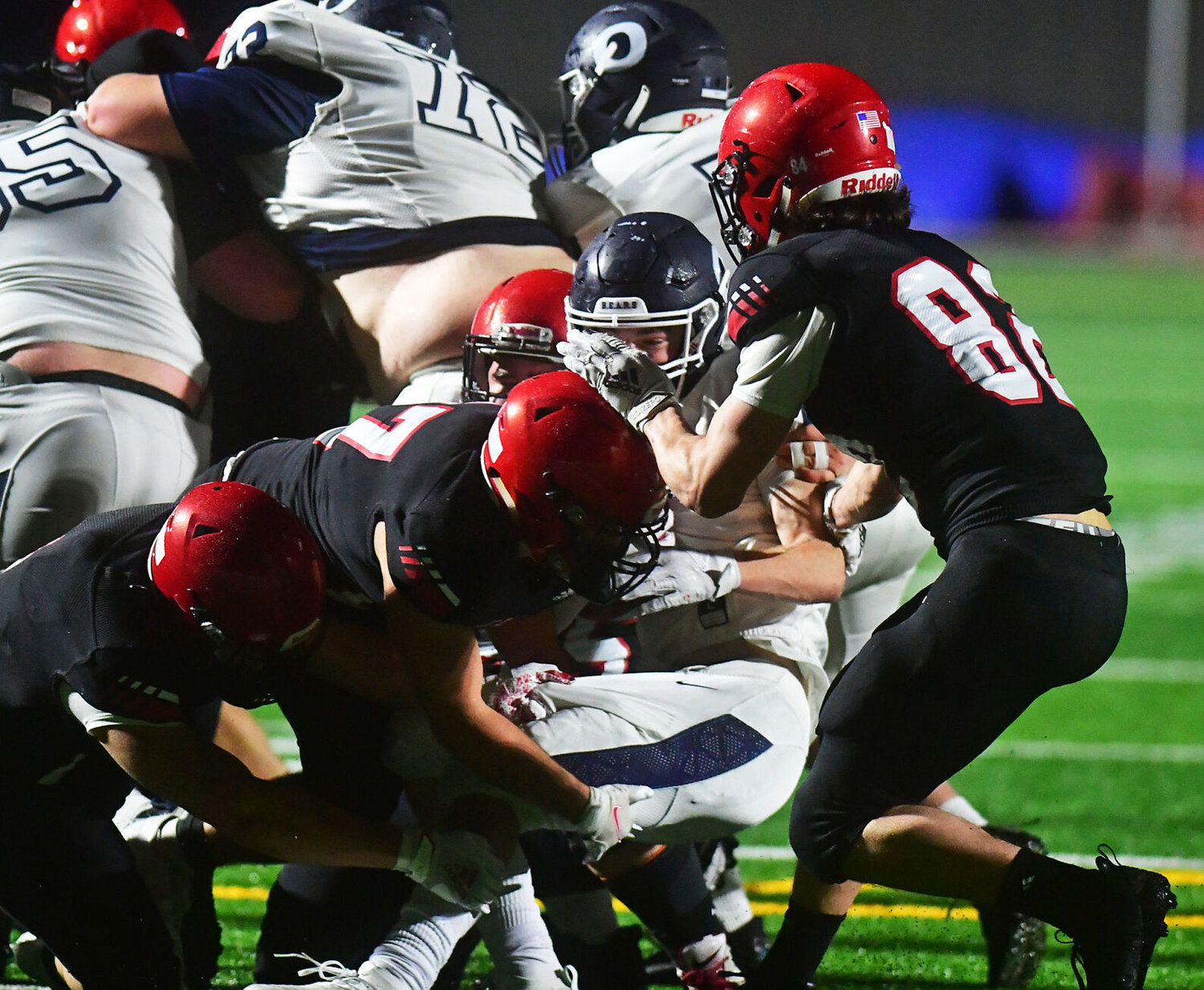 Yelm High School defenders smother an Olympia High School running back on Friday, Feb. 19, at the YHS stadium.