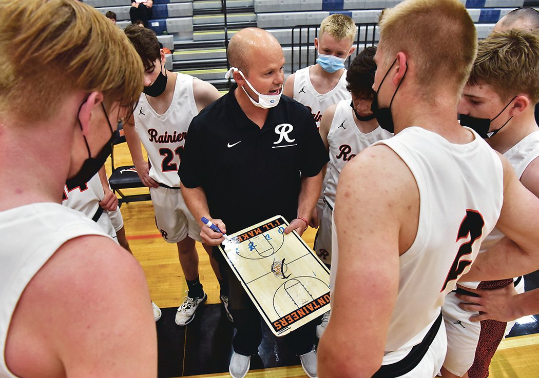 Jeremy Landram, Rainier High School head boys basketball coach, discusses strategy with his team during a timeout in Rainier’s practice game against Yelm High School on Saturday, May 1, in Rainier.