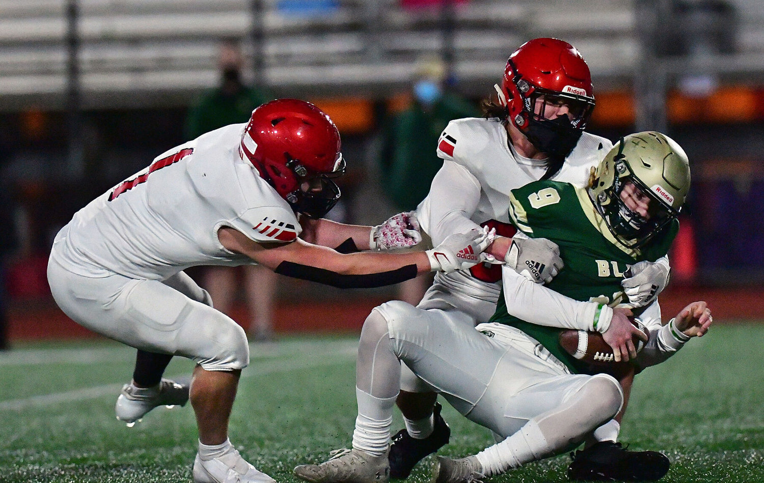 Ray Wright (left) helps take down Timberland High School quarterback Jackson Brown on Friday, March 12, at South Sound Stadium.
