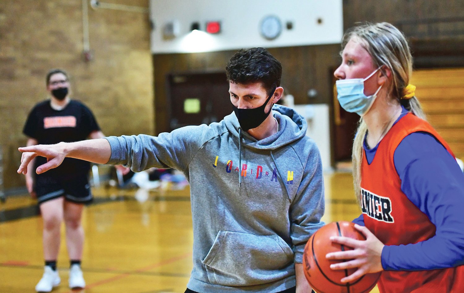 Brandon Eygabroad, Rainier High School girls basketball coach, instructs Rainier player Kaeley Schultz during practice on Friday, April 30, before the start of the regular season.