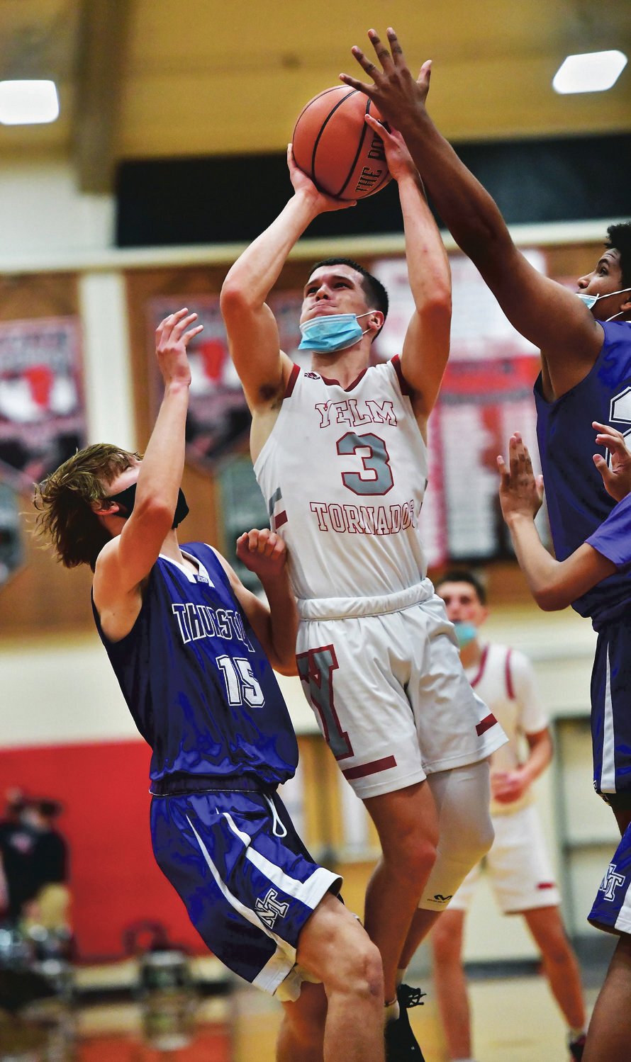 Yelm High School guard Jeshua Hardie, in white, shoots over North Thurston High School defender Tristan DeVere, left, during basketball action on Friday, May 21, in Yelm.