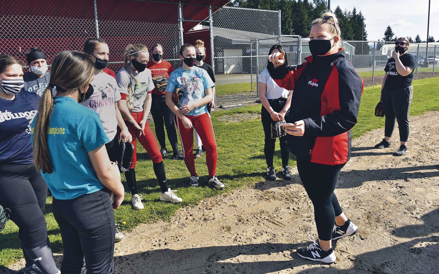 Yelm High School softball Head Coach Lindsay Walton instructs her players during practice on Wednesday, March 17.