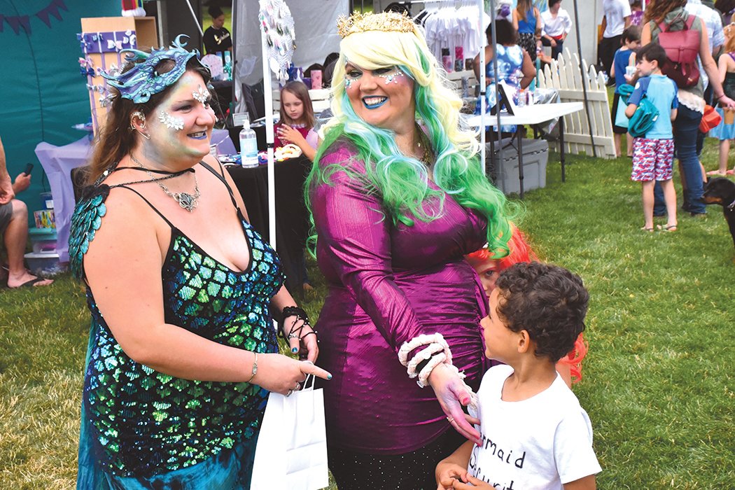At center, Rebecca Howard, of Roy, shows off her costume with friends and family at the Yelm Mermaid Festival on Saturday, July 17, at Yelm City Park. Howard was one of 10 adult mermaid contest entrants.