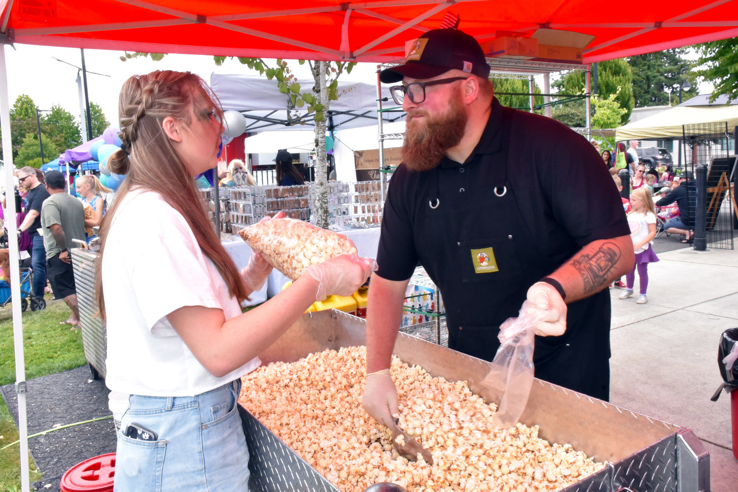 Popcorn vendors work hard to supply the thousands of mermaids hungry for fair food at the 2021 Yelm Mermaid Festival on Saturday, July 17, at Yelm City Park.