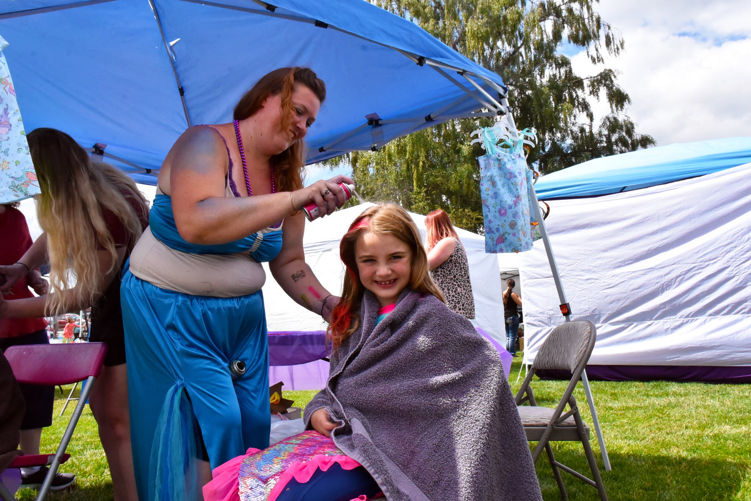 What's a mermaid festival without mermaid hair? One antendee of the 2021 Yelm Mermaid Festival gets colorful hair on Saturday, July 17, at Yelm City Park.