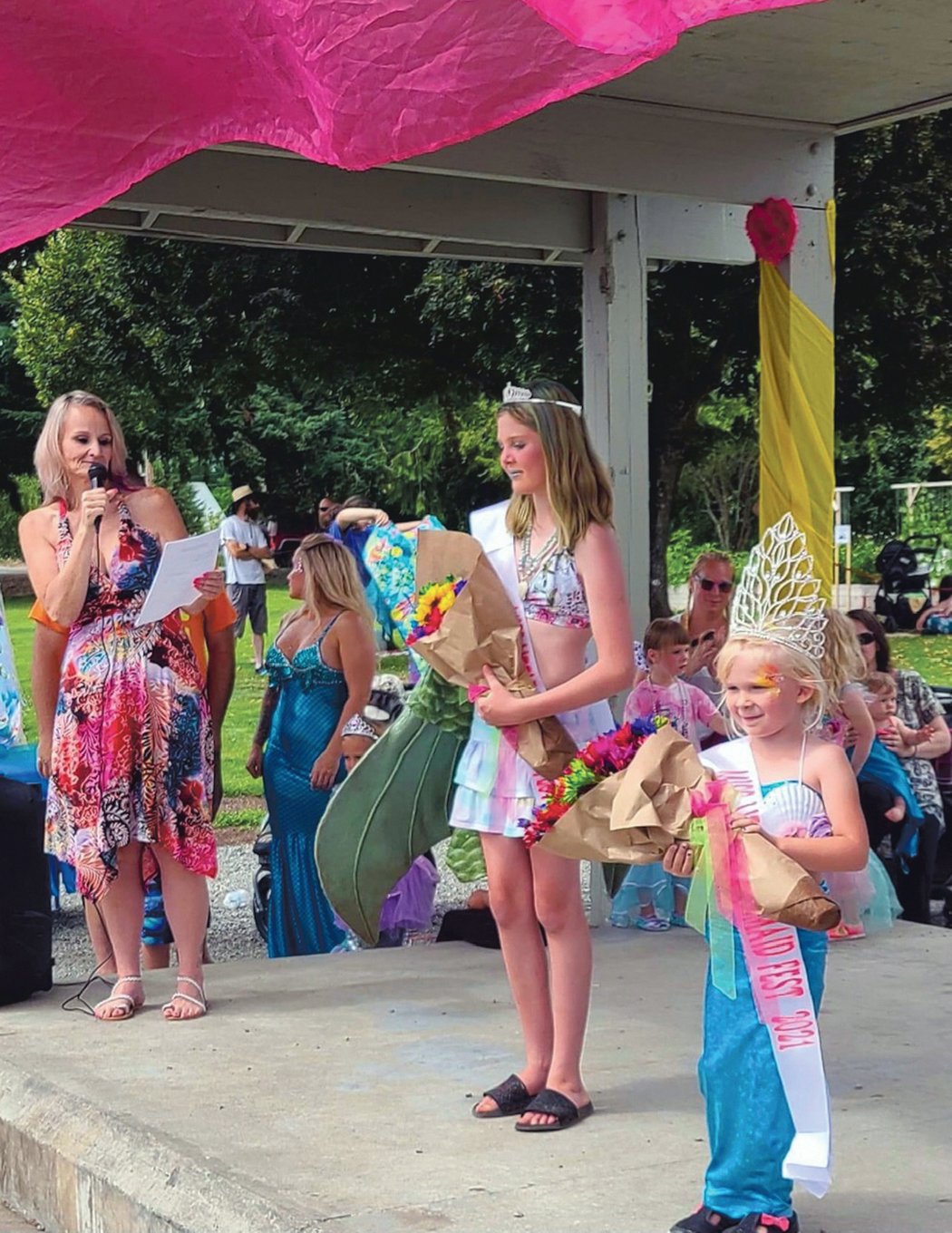 At right, the 2021 Kids Mermaid Fest Queen Keegan Mcmenamy, of Rainier, and 1st runner up Sophia Heidinger, of Chehelis, center, accept their crowns at Yelm Mermaid Festival Saturday, July 17, at Yelm City Park.