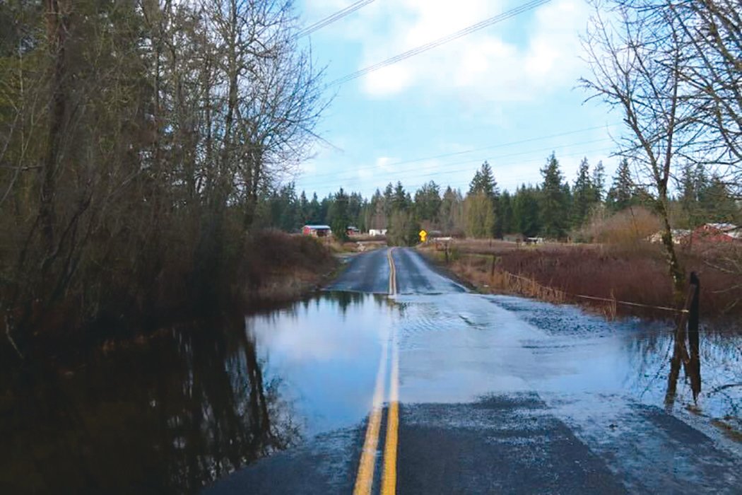 A portion of Tisch Road in Roy is pictured with water over the roadway on Friday, Jan. 7.