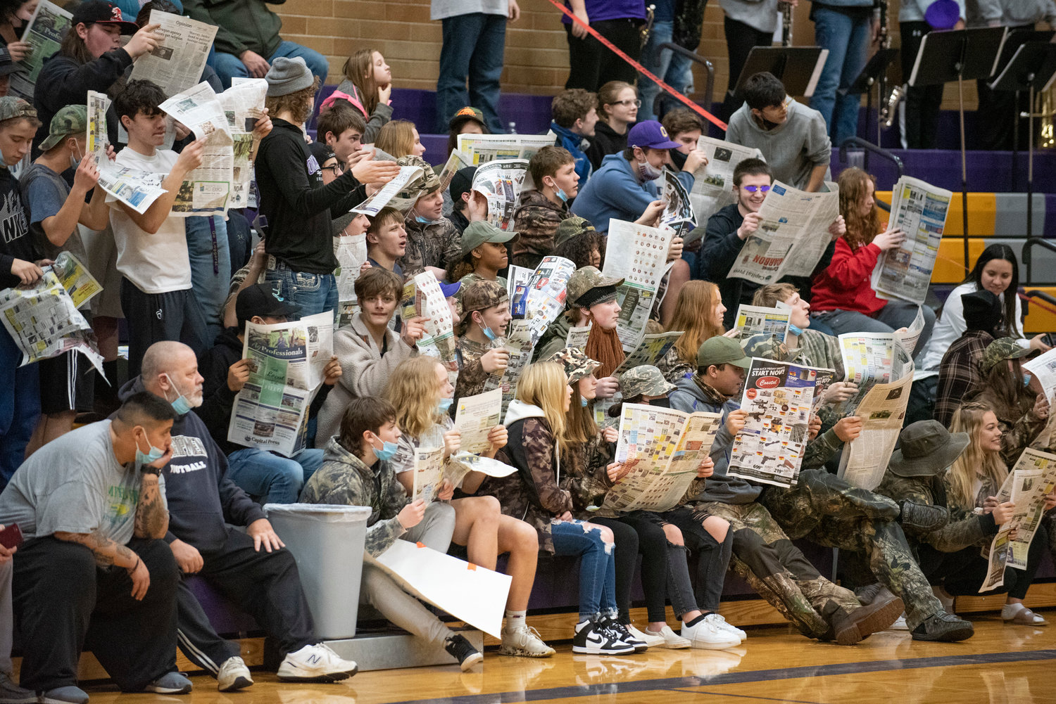 Onalaska's student section reads newspapers while a Rainier player shoots free throws during a home game on Jan. 20.