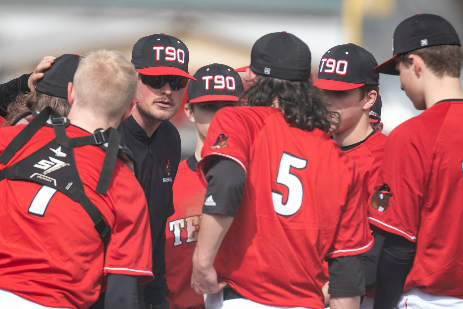 Tenino baseball coach Ryan Schlesser talks to his team between innings of a home game agaisnt Toledo on March 16.