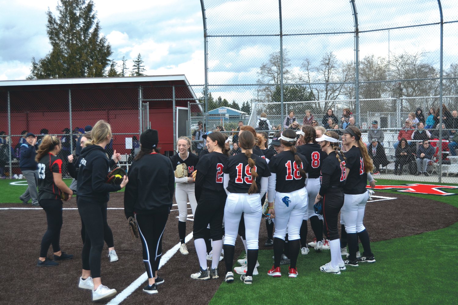 Drea Schwaier, Tayelyn Cutler, Ashley Ellis and Taylor Gubser embrace the 2022 Yelm fastpitch team prior to their matchup with North Thurston.