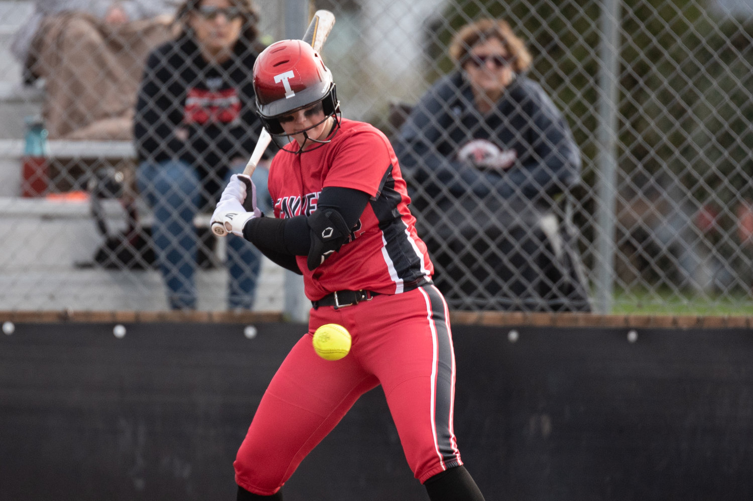 Tenino catcher Courtney Backman looks at a pitch against Rainier March 24.