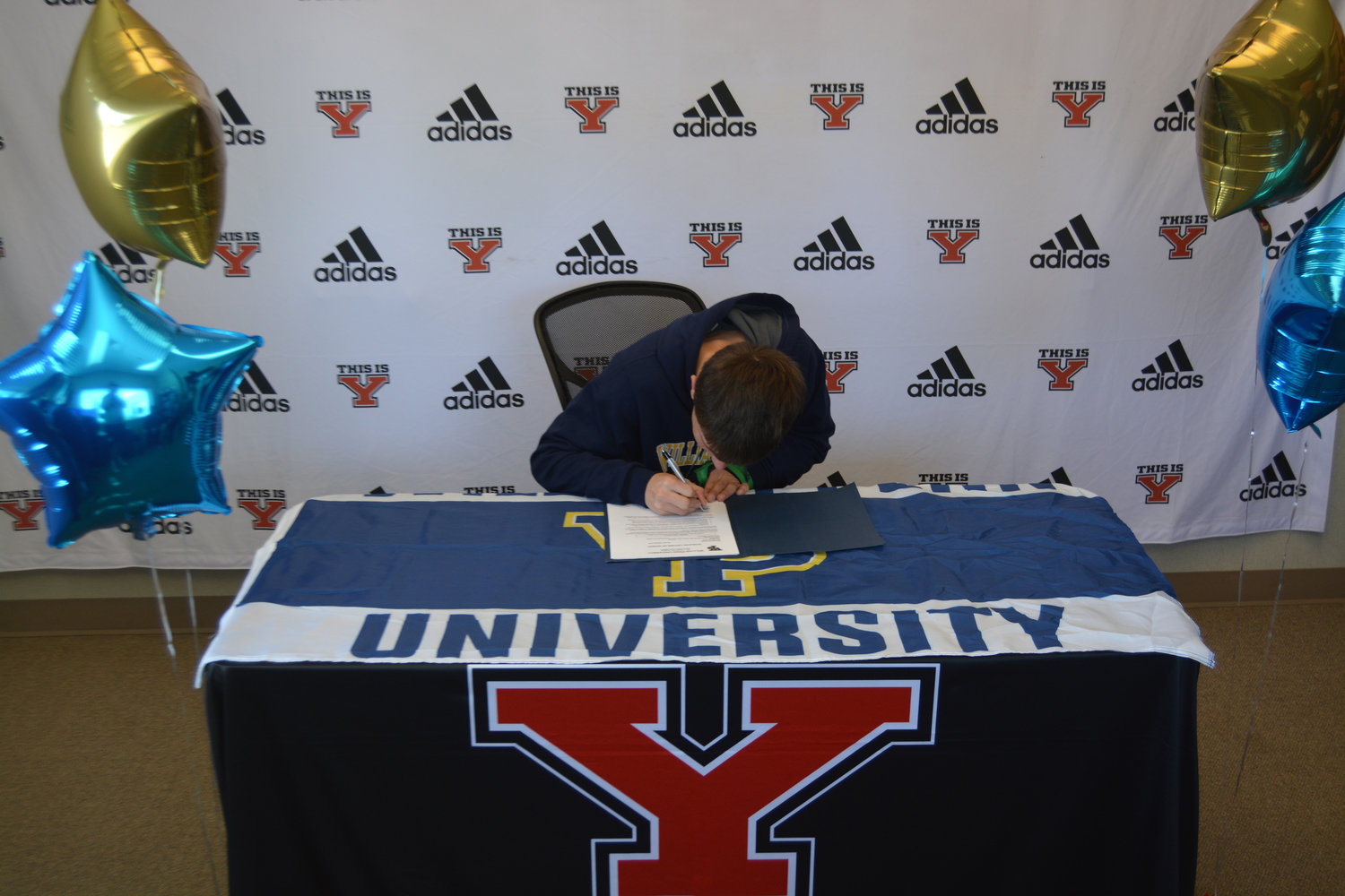 Yelm wrestler Jeffrey Myers puts ink to paper to officially join the William Penn University wrestling team.