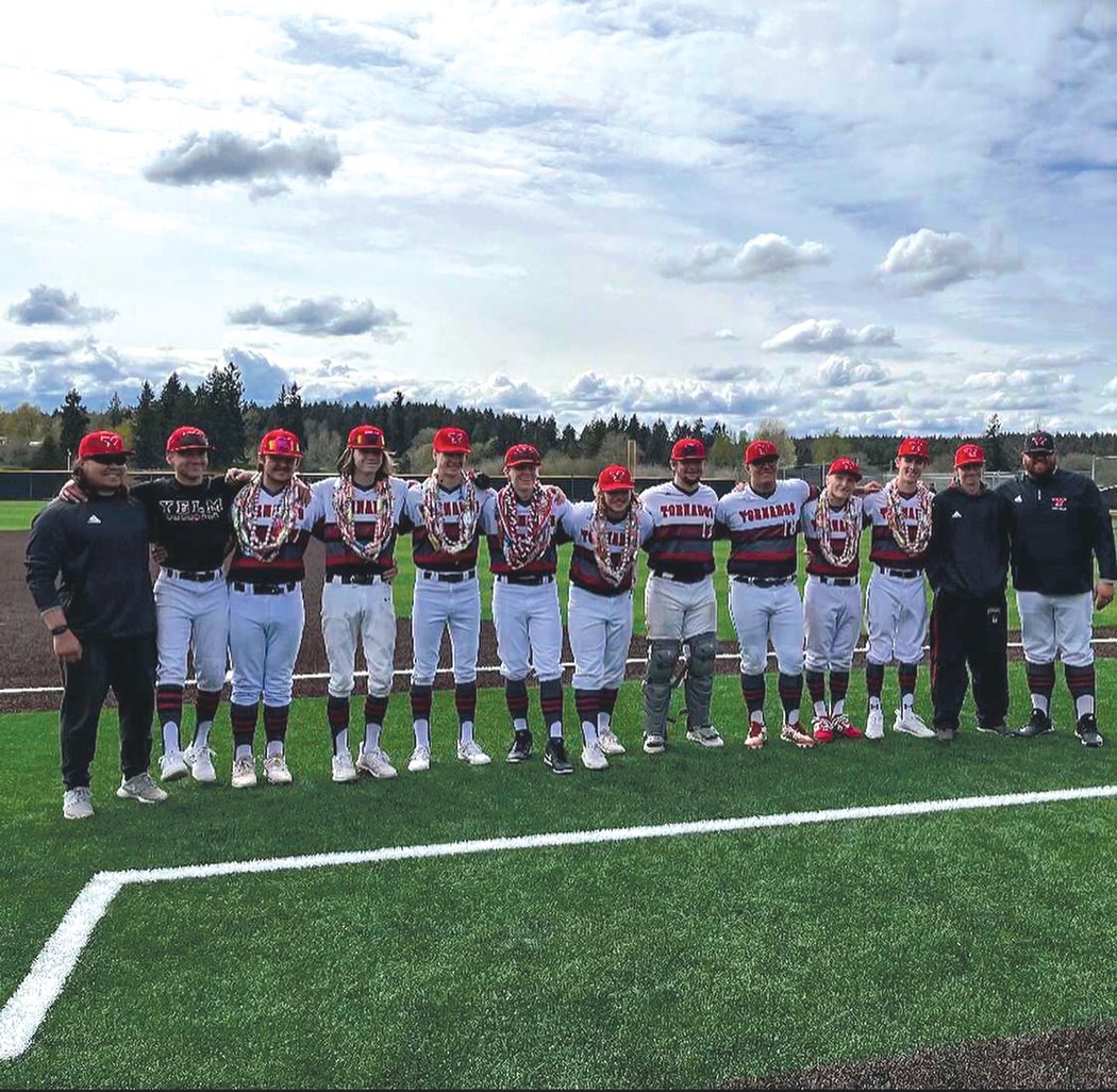 Yelm’s coaching staff poses for a picture with the team’s seniors prior to their matchup with Rainier on April 29.