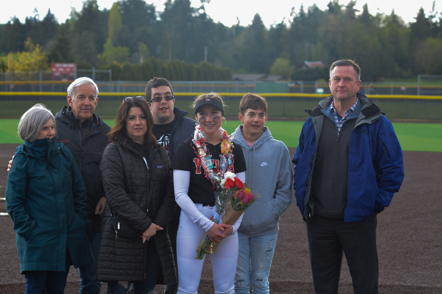 Senior second baseman Molly Embrey poses for a photo with her family following the senior night contest on May 9.