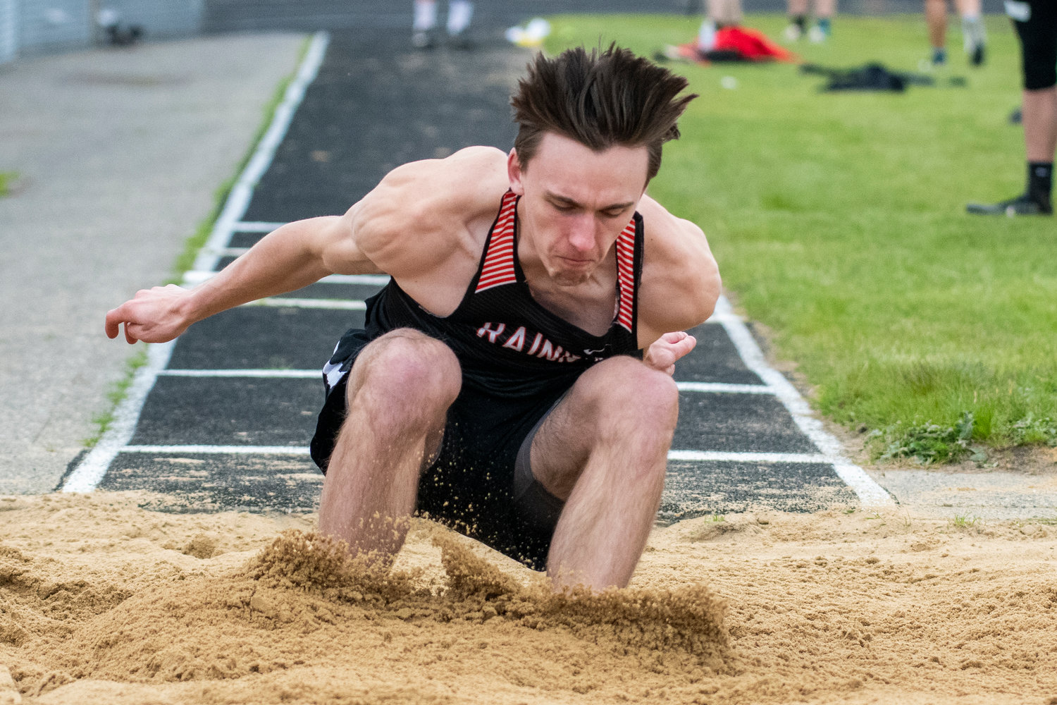 Rainier's Thomas Ronne hits the triple jump pit during the Central 2B League Championships on May 13.