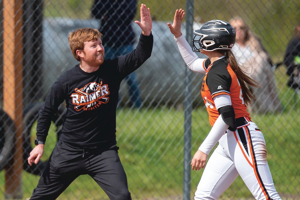 Rainier head coach Kyle Greenwood, left, high-fives Keira Anderson after Anderson hit a triple against Toledo on April 25.