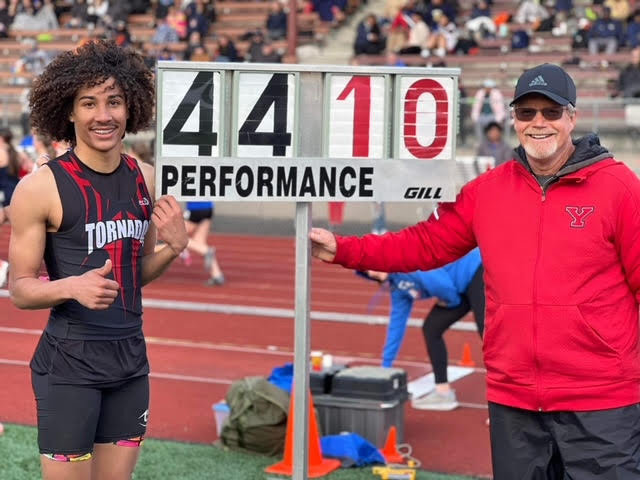 Trevontay Smith poses with Coach Phil Lonborg after he set his personal record in triple jump.