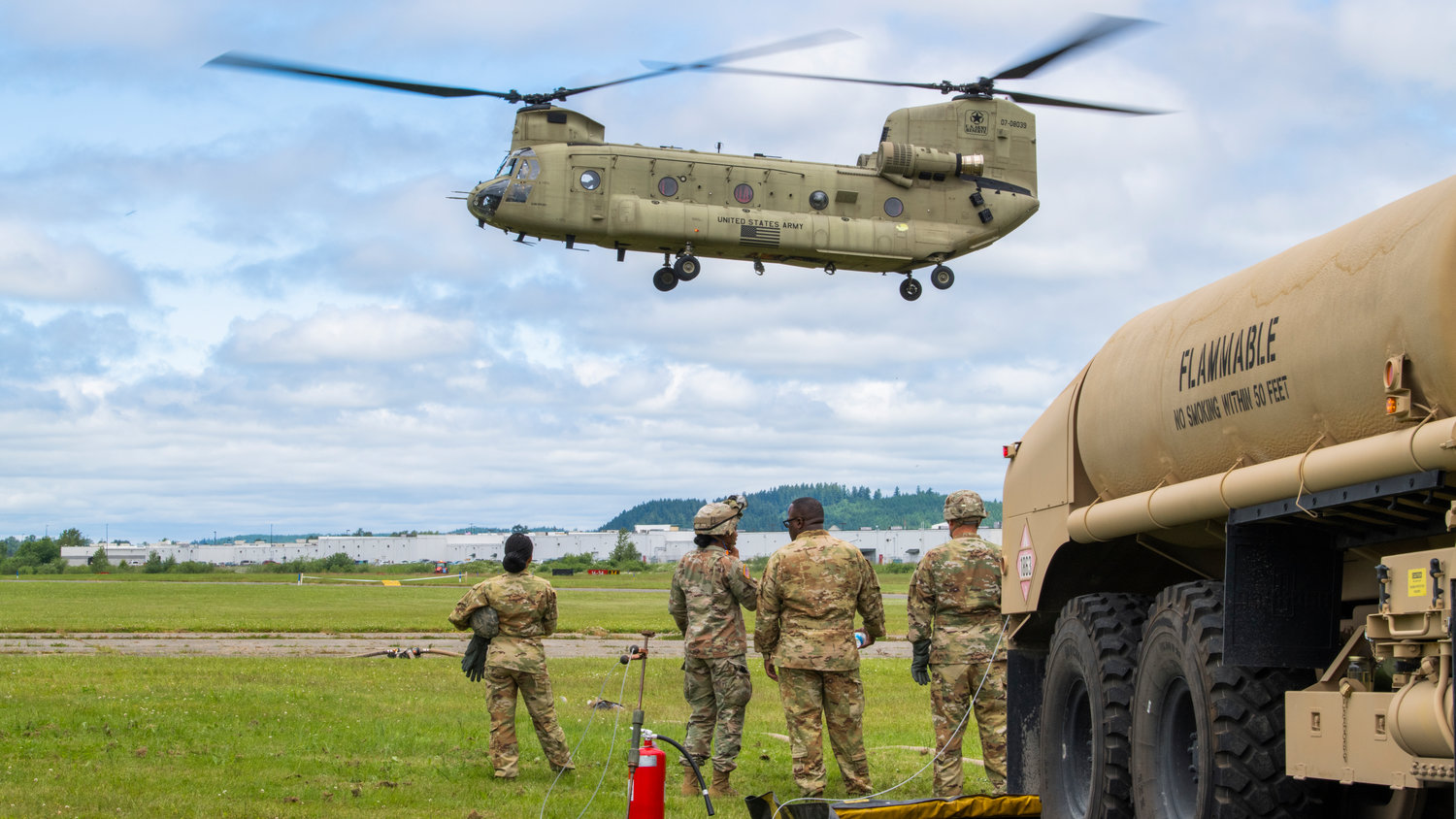 Members of the United States Army from Joint Base Lewis-McChord watch as a Chinook helicopter prepares to land at the Chehalis-Centralia Airport during a military training exercise on Wednesday, June 22.