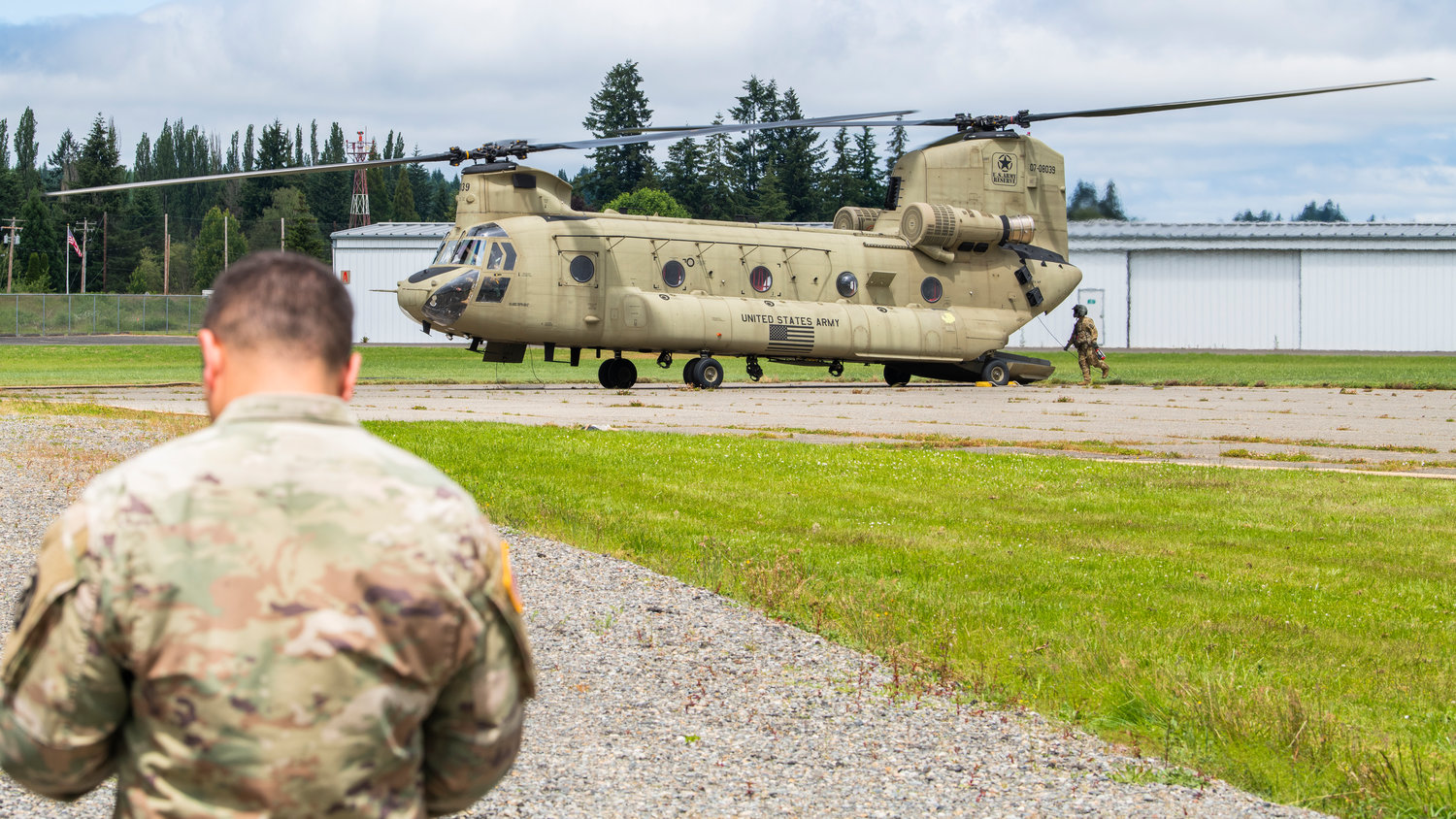 Crews from Joint Base Lewis-McChord exit a Chinook helicopter after a landing at the Chehalis-Centralia Airport as they prepare to fuel up during a military training exercise on Wednesday, June 22.