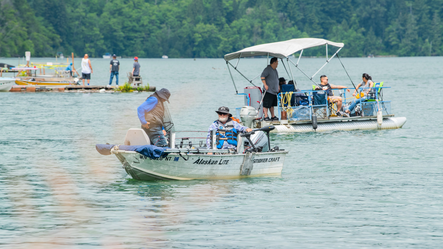 Boaters bask in the sun as visitors fish at Mineral Lake on Saturday.