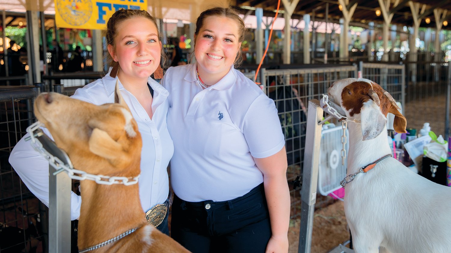 Callie Thomas and Clara Price, of Chehalis, smile for a photo with goats Lani and Charlie at the Thurston County Fair on Thursday, July 28.