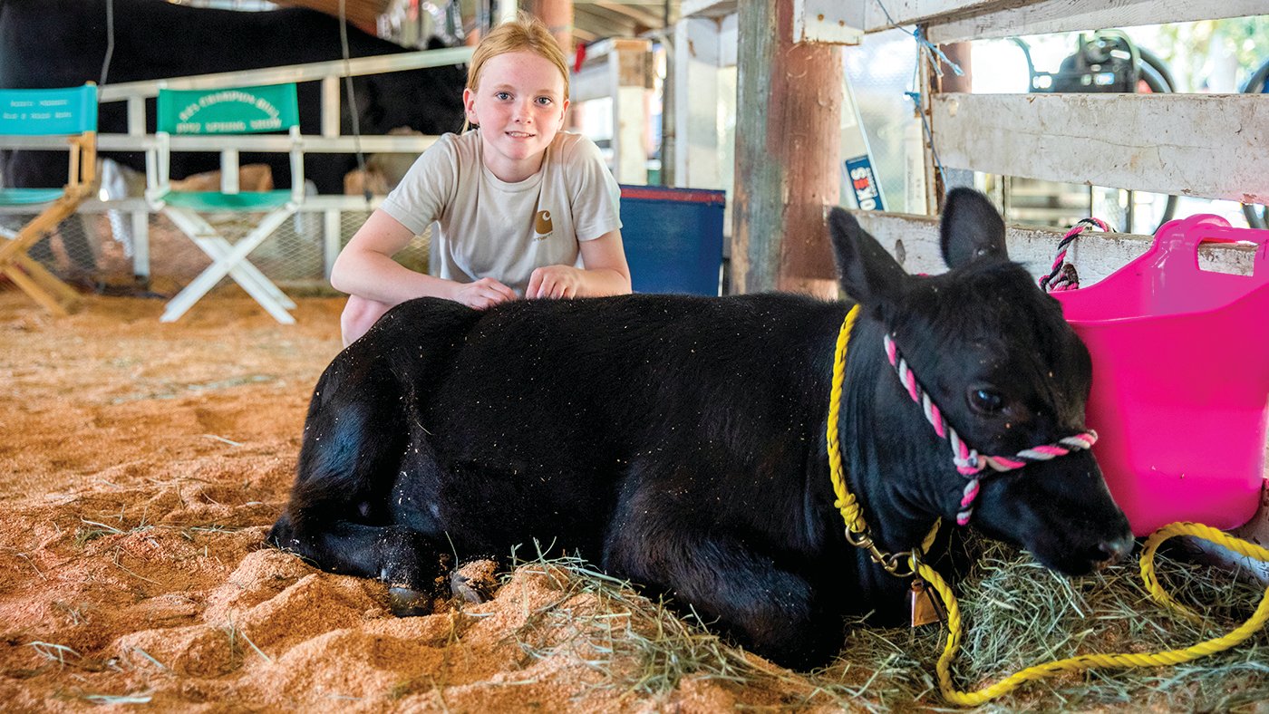 Kyla Watson, 13, of Tenino, smiles for a photo on Thursday, July 28 with Sandy, her Angus cow, during the Thurston County Fair in Lacey.