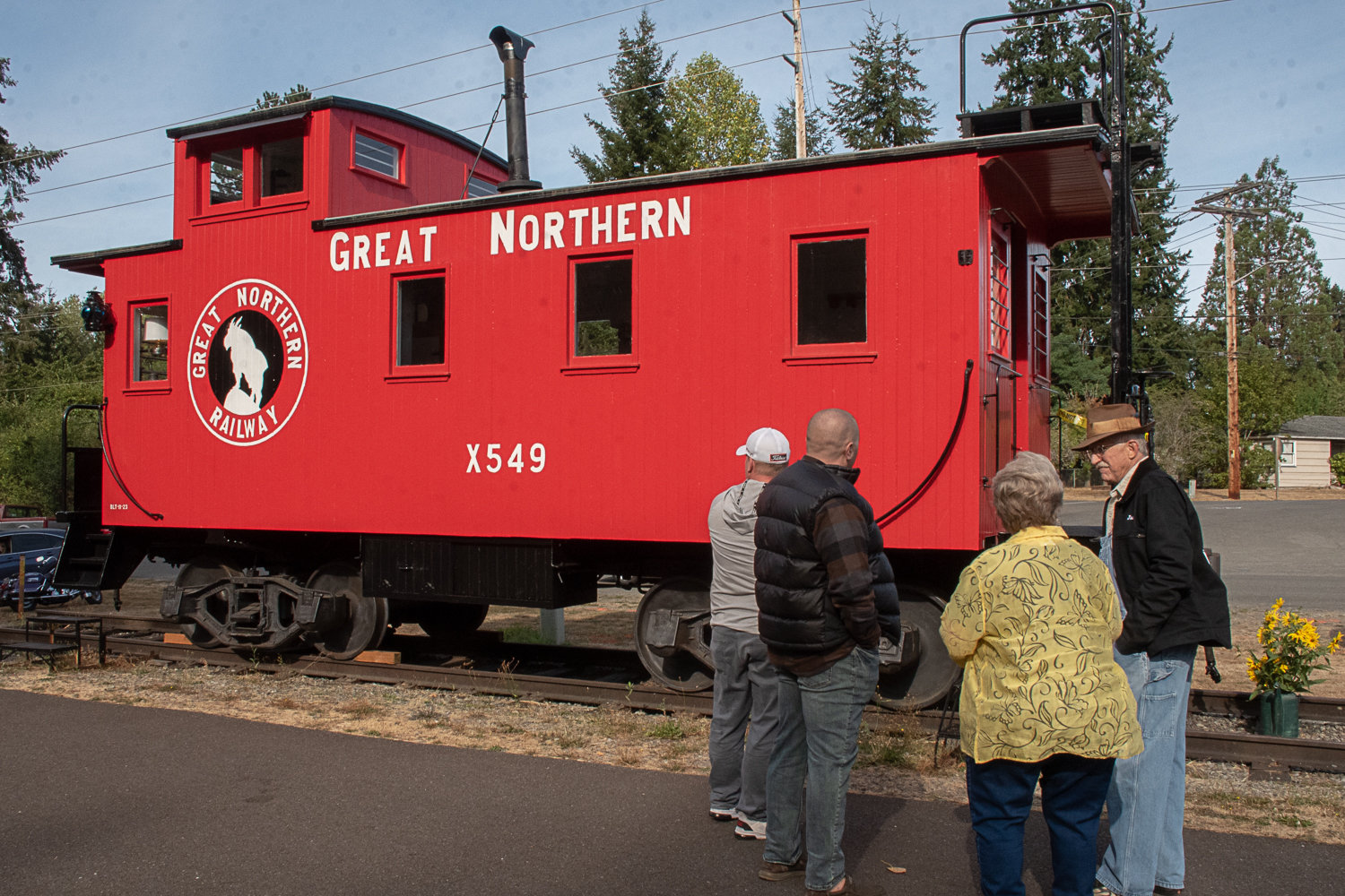 From left to right, Tenino City Council member Jason Lawton, Tenino Mayor Wayne Fournier, Tenino City Council member Linda Gotovac talk to Jan Wigley, of Centralia, a retired metal worker who did the fabrication and welding necessary to restore the caboose.