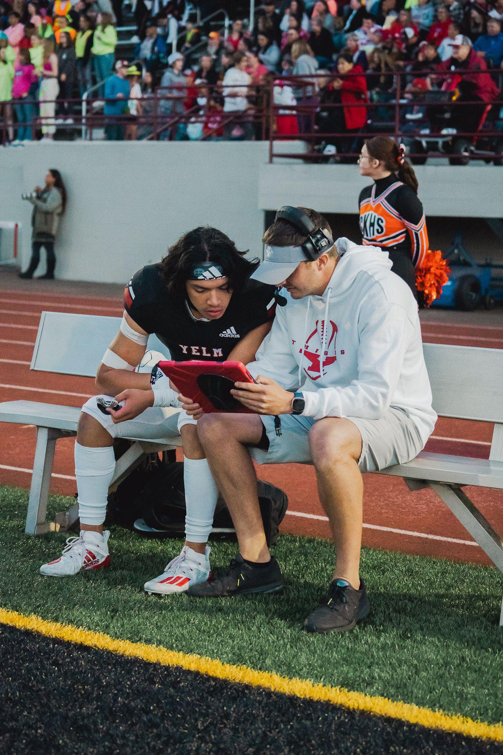 Offensive coordinator Bryan Irion looks over film with quarterback Damian Aalona during the game against Central Kitsap.