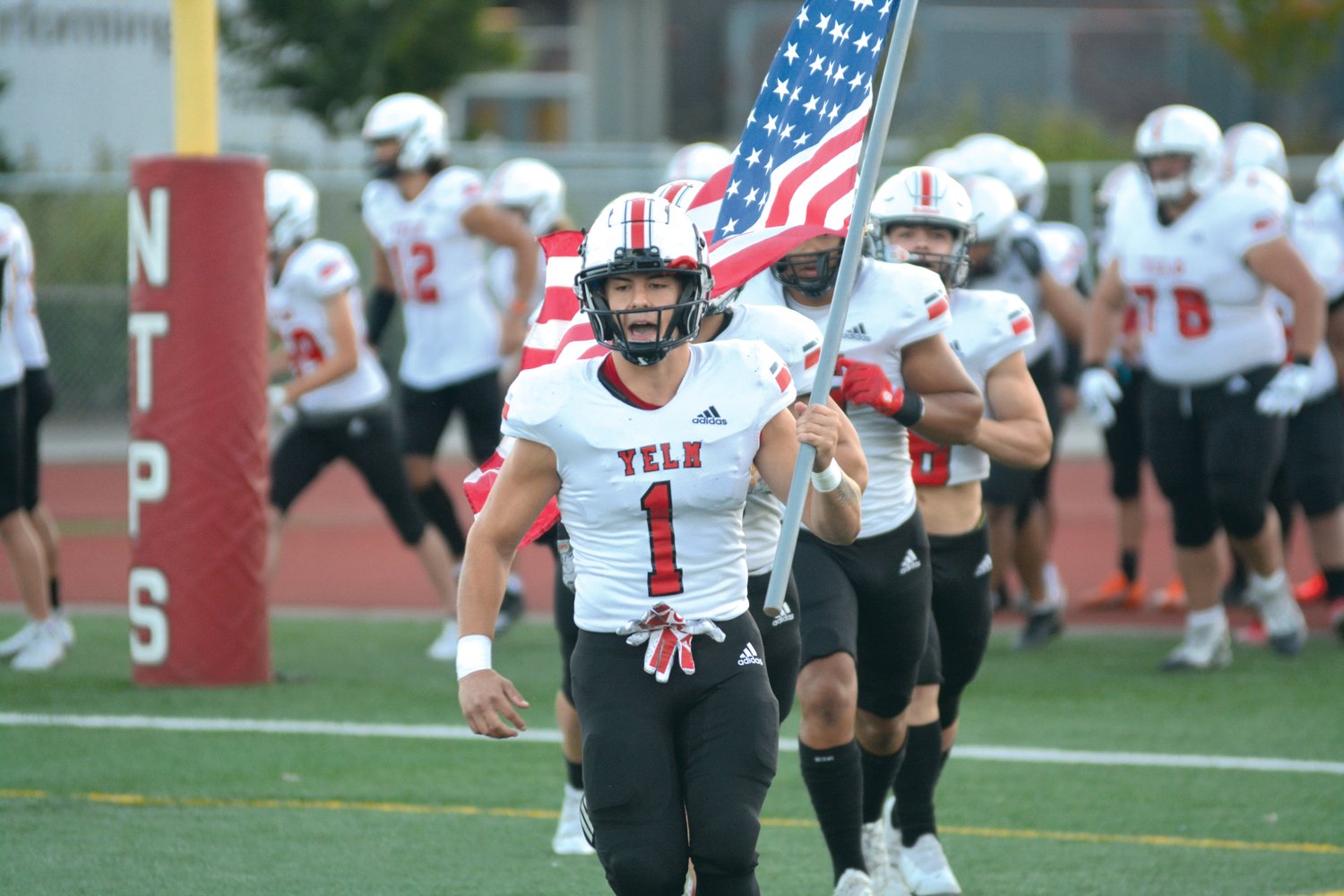 Senior linebacker and captain Ray Wright holds the American flag as the Tornados enter the field against River Ridge.