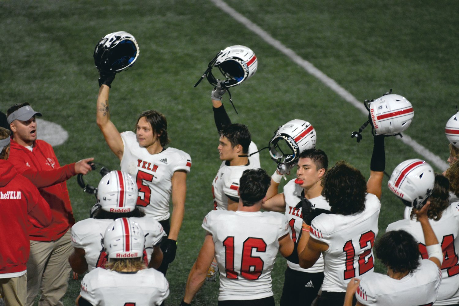 The Tornados lift their helmets at the start of the fourth quarter during their game against River Ridge on Friday, Sept. 23.
