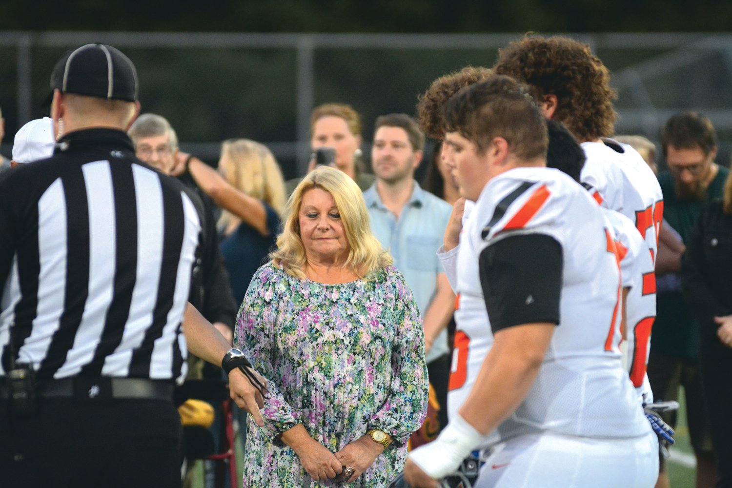 Jo Kain, who was a special guest for the coin flip, watches on as a coin falls to the ground on Sept. 29.