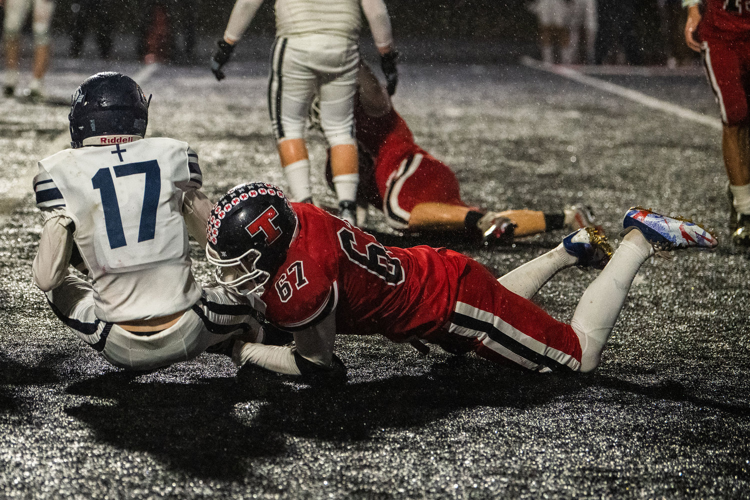 Tenino junior E.J. Haigler (67) makes a tackle Friday night at Beaver Stadium during a game against the King’s Way Christian Knights.