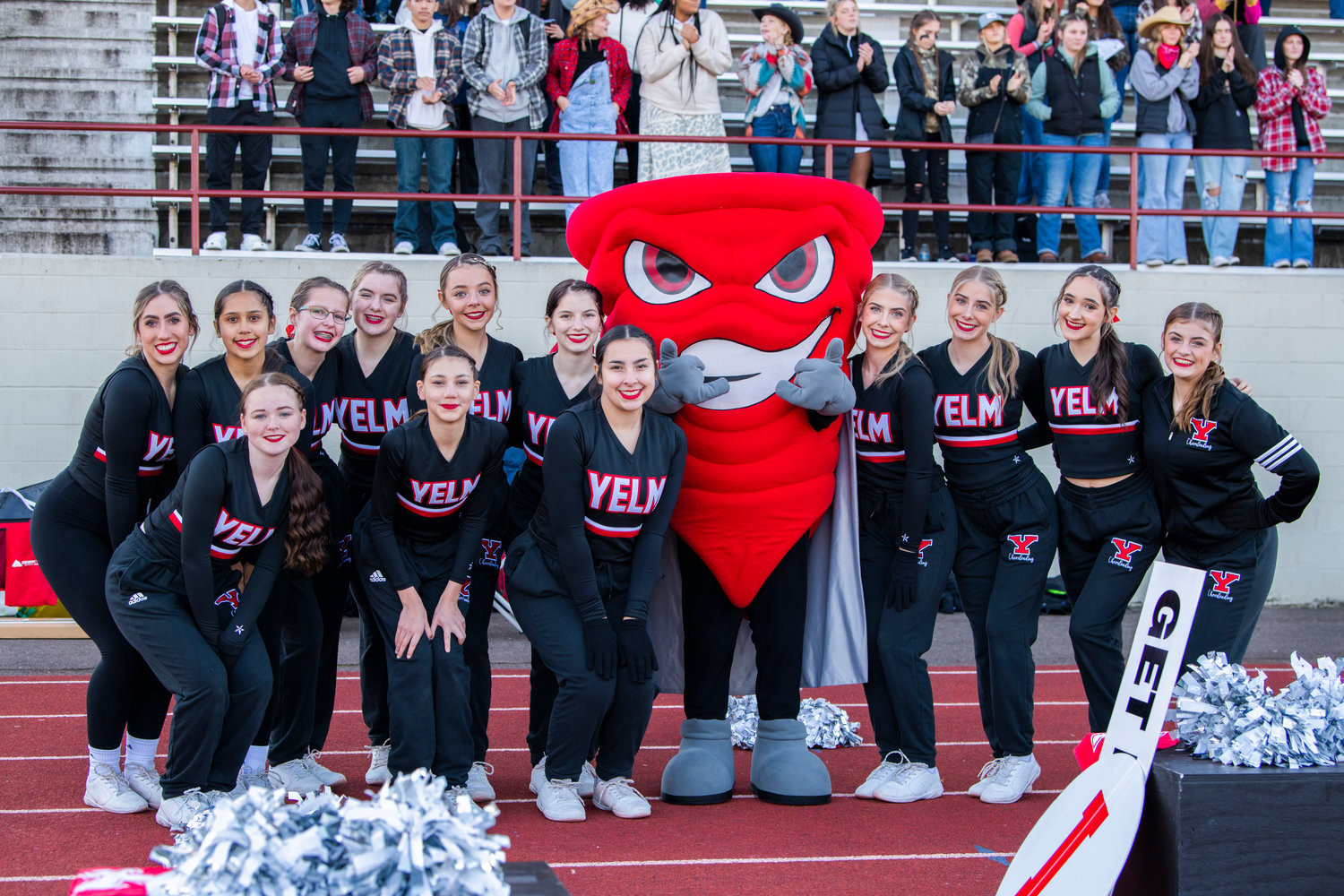 Tornado cheerleaders smile and pose for a photo with the Yelm High School mascot during a footbal game on Saturday.