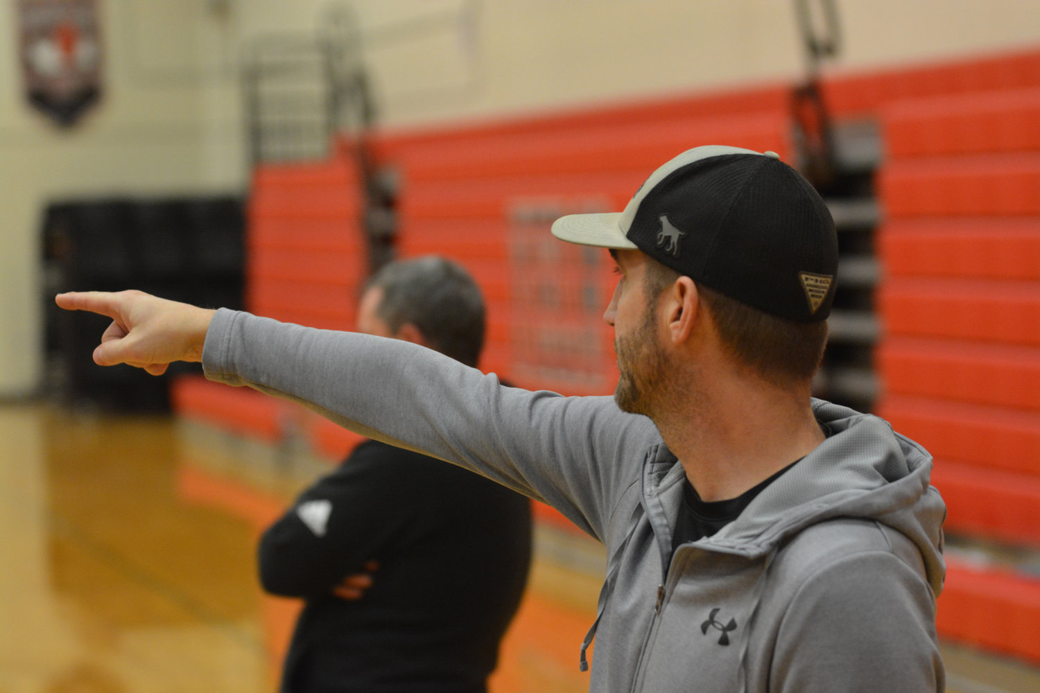 Head coach Dave Wasankari points to his players while they practice a defensive drill.
