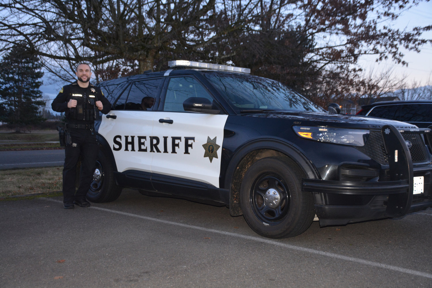 Thurston County Sheriff Derek Sanders poses for a photo in front of his car on Monday, Jan. 16.