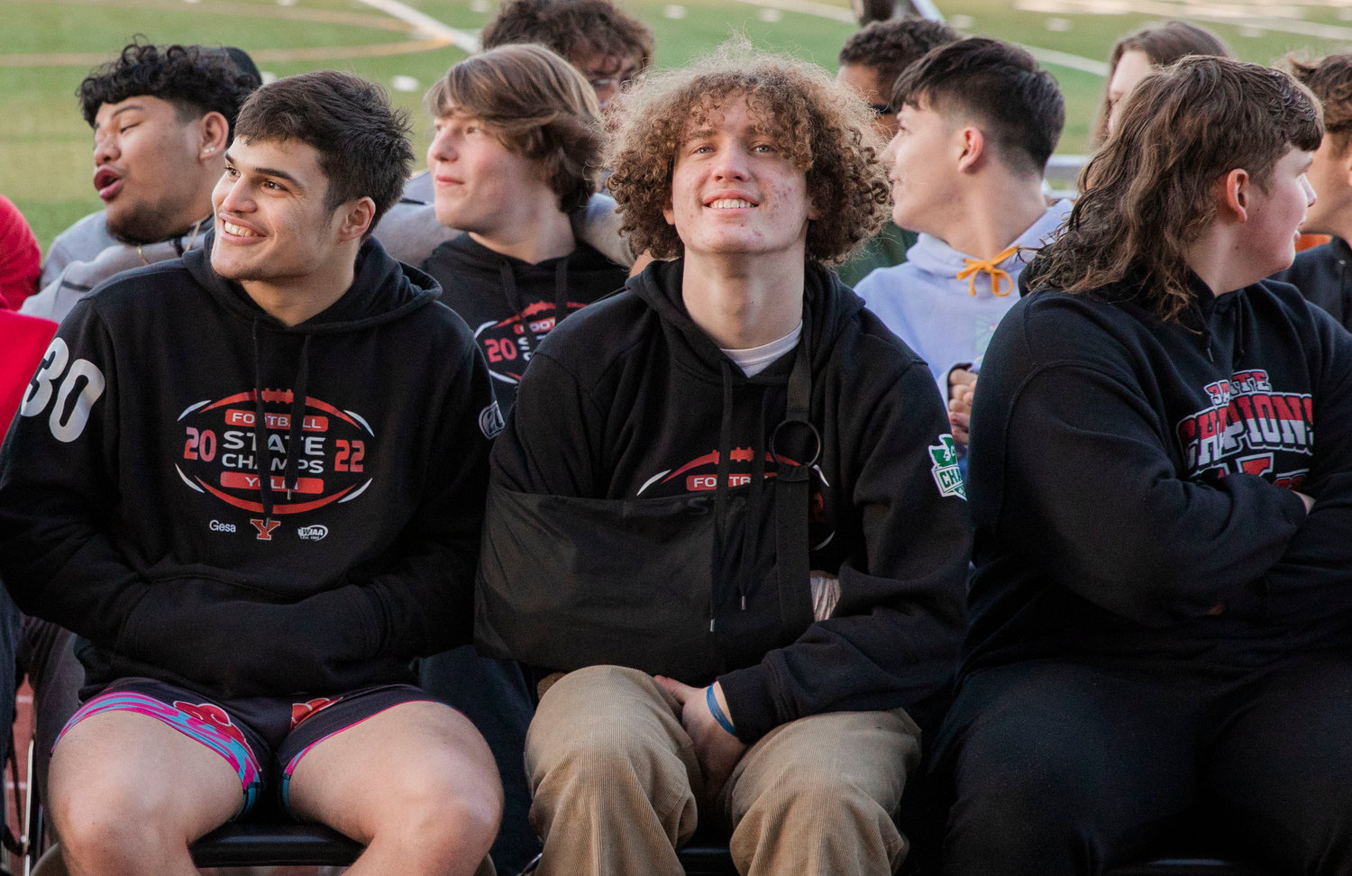 Athletes look on as Tornado fans cheer following a celebration parade in Yelm Monday evening.