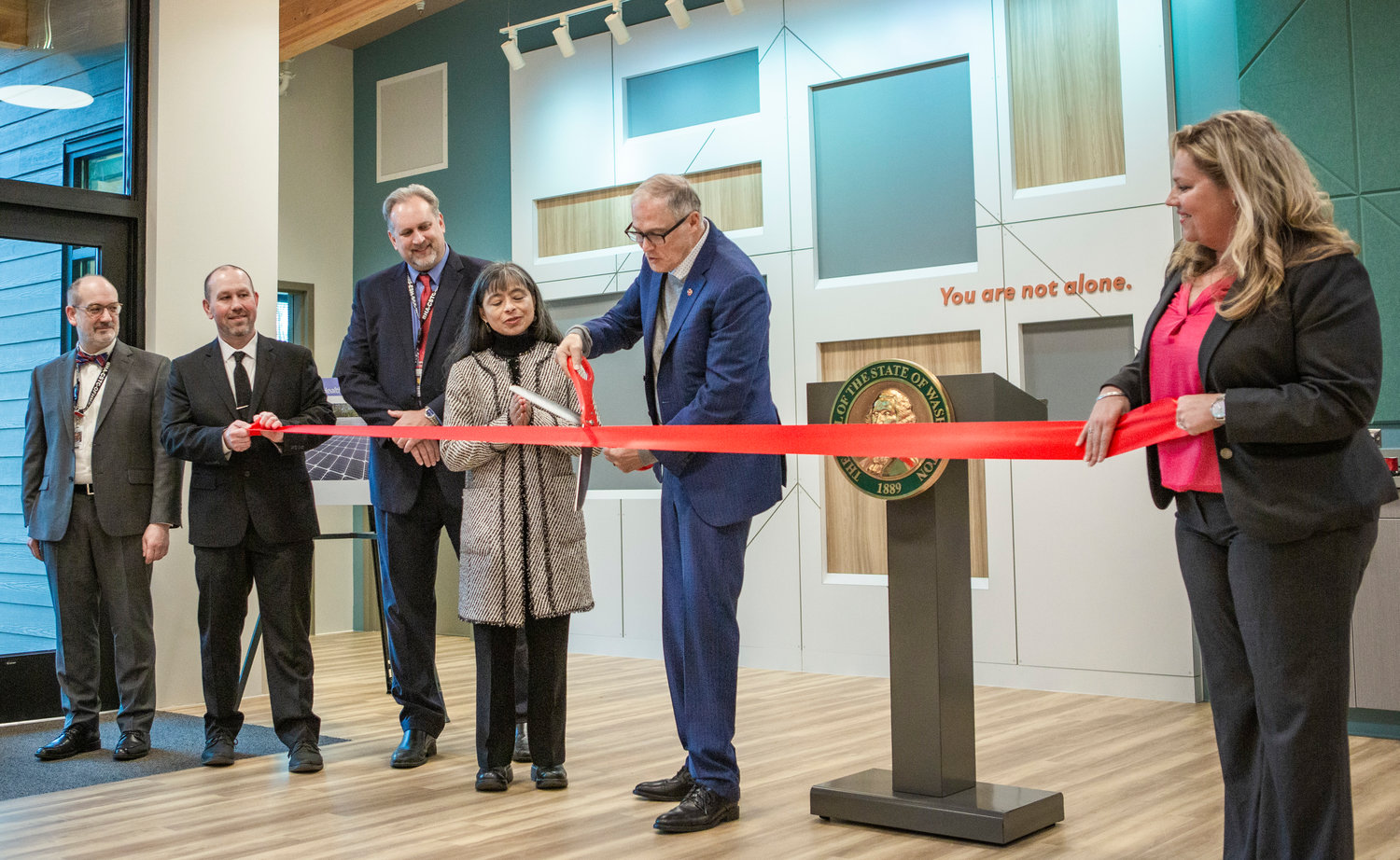Gov. Jay Inslee cuts a ribbon inside a new behavioral health facility at Maple Lane School between Centralia and Rochester on Friday, Jan. 27.