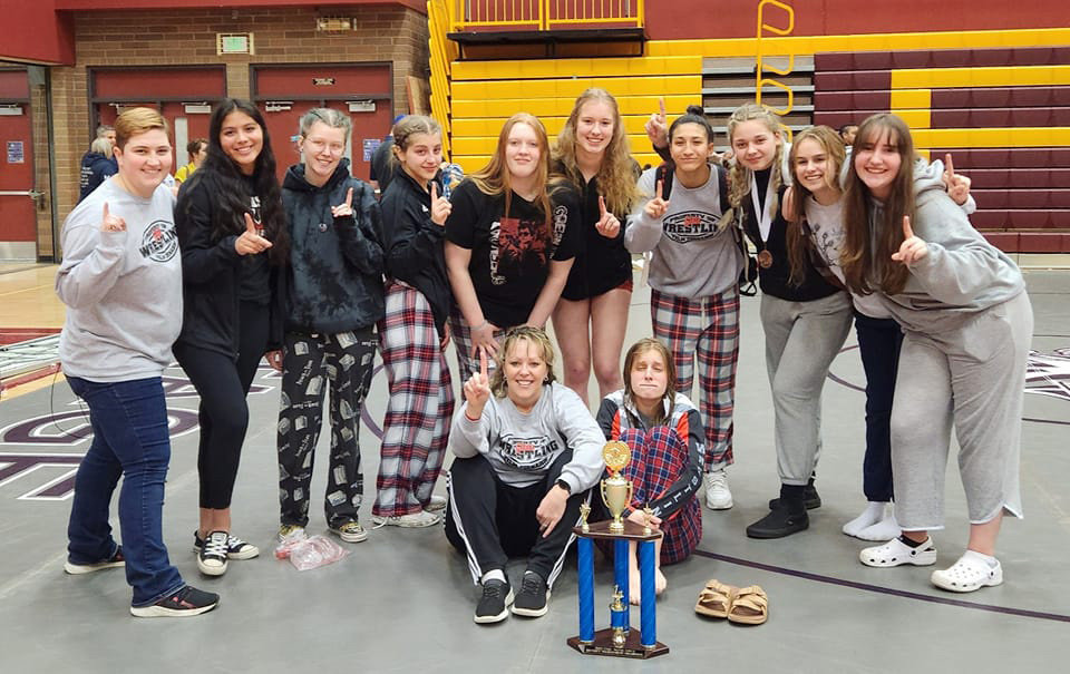 The Yelm girls wrestling team poses for a photo following their first place finish at the district tournament.