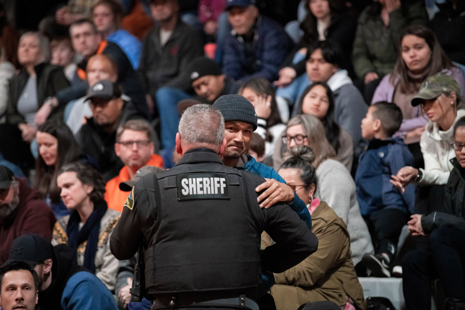 Sopheak Uch, the father of Jessie Uch, receives an embrace from a member of the Thurston County Sheriff’s Office, which is leading the investigation, during a vigil at Rainier High School on Tuesday.