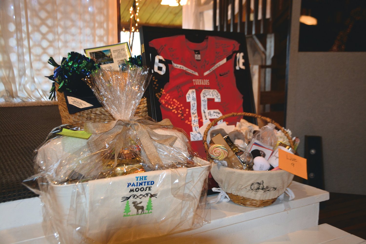 Several auction items sit at the front of the Lake Lawrence Lodge prior to the Yelm Dollars for Scholars auction on Saturday, March 11.