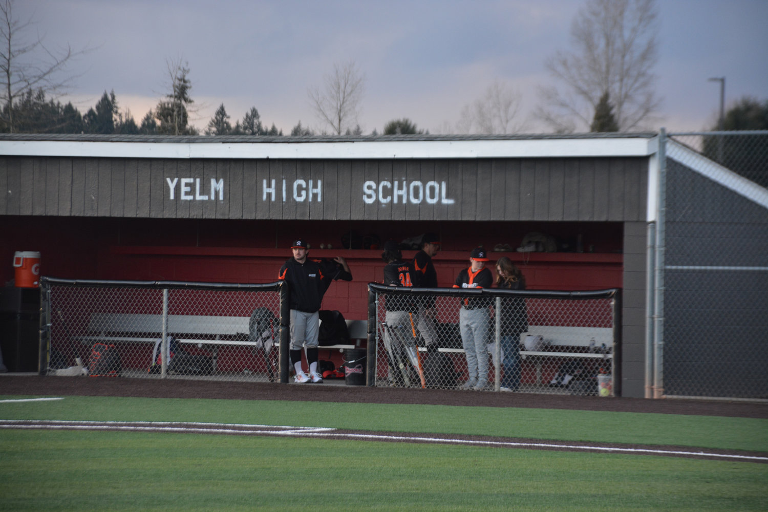 Rainier baseball players converse in the dugout during their first game of the year against Yelm on Friday, March 10.