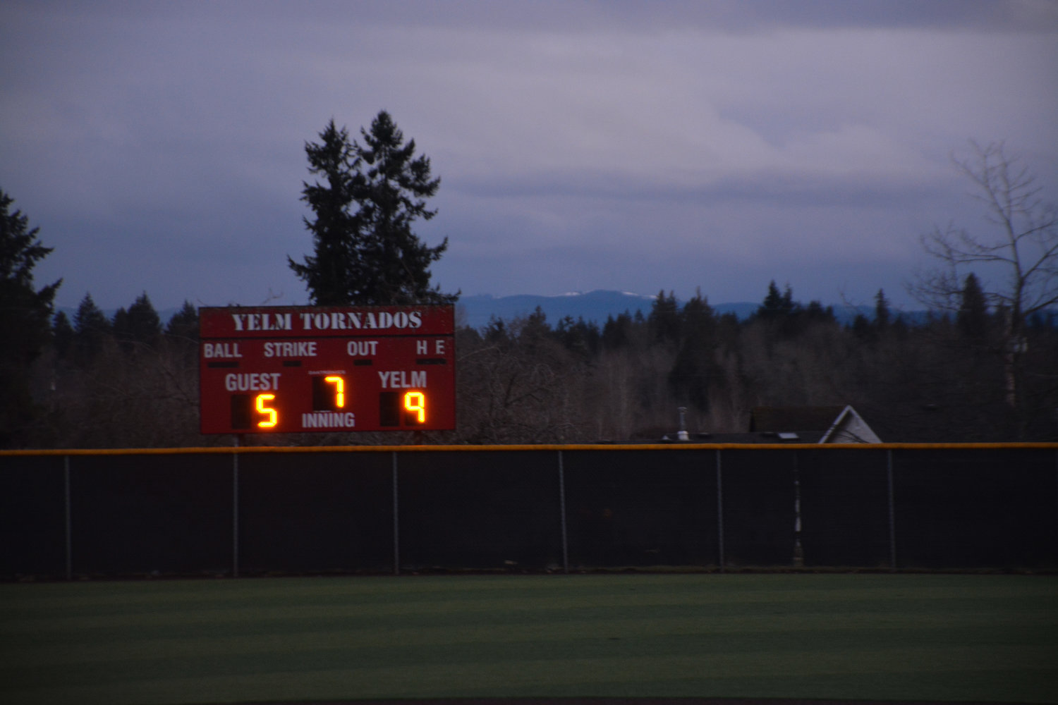 Snowy mountain caps sit behind the final 9-5 score of the Yelm versus Rainier game on Friday, March 10.