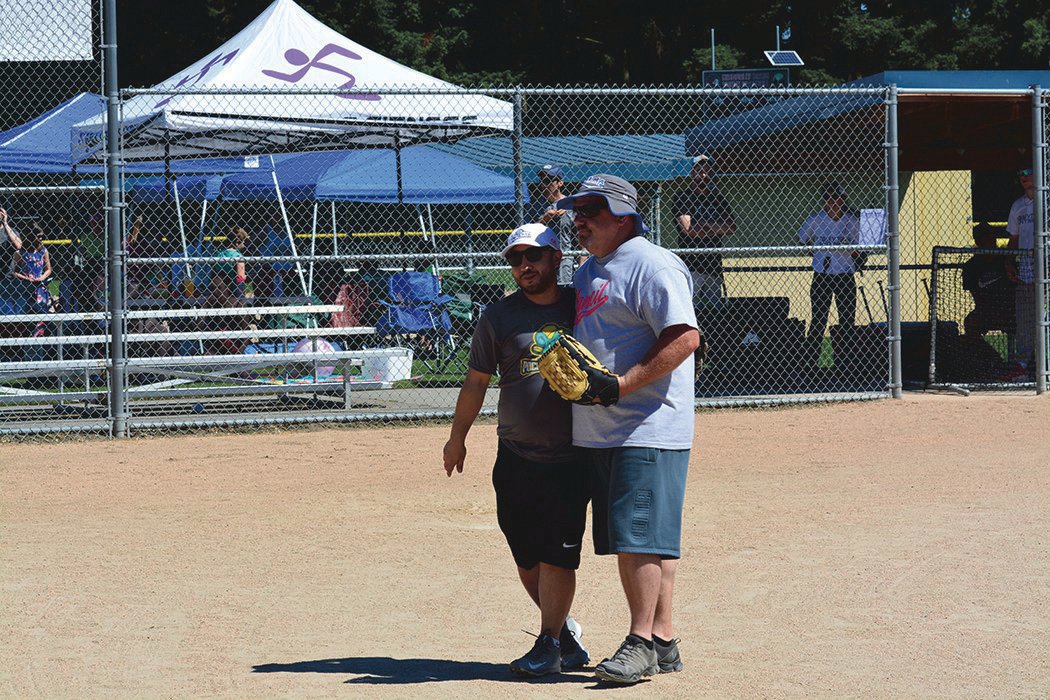 Yelm Mayor Joe DePinto embraces former Yelm Chief of Police Todd Stancil, who threw out the celebratory first pitch during the second annual mushball tournament on June 26, 2022. This year’s event will be held on June 25 at Longmire Park.